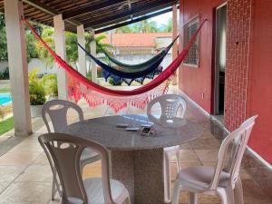 un patio con mesa, sillas y hamaca en CASA LAGOA DO BANANA/CUMBUCO en Caucaia