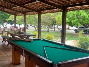 a pool table sitting under a pavilion with a table at CASA LAGOA DO BANANA/CUMBUCO in Caucaia
