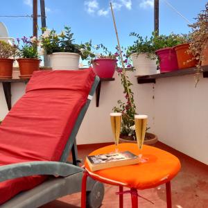 una mesa con un cojín rojo y una mesa con dos vasos. en Casa Flores, en Arrecife