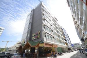 a tall building with a restaurant in front of it at The Patong Center Hotel in Patong Beach