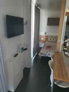 Habitación con cama y TV. en Two Roses Mobile Home en Jezera