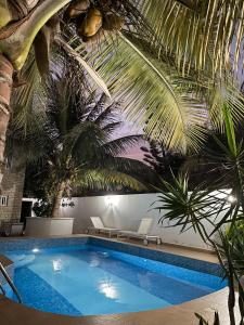 a swimming pool with palm trees and a ceiling at Francesca Guest House in Dakar