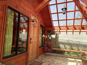 a porch of a house with a glass door at Cabañas El Diuco en Coñaripe 4 in Coñaripe