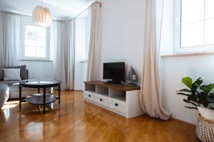 ein Wohnzimmer mit einem Sofa und einem TV auf dem Tisch in der Unterkunft PortHouse Apartments in Piran
