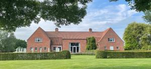 a large red brick house with a green yard at HuysHoeve in Knokke-Heist