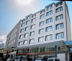 a large white building with cars parked in front of it at KURT OTEL in Degirmen