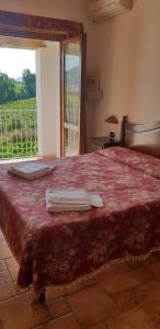 a bedroom with a bed with a red blanket and a window at Agriturismo Vermentino in Monti