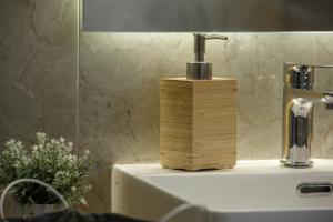 a wooden soap dispenser sitting on top of a sink at Théa boutique villas sivota III in Sivota +35 photos