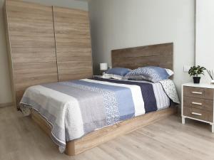 um quarto com uma cama grande e uma cabeceira em madeira em Tenerias em Castellón de la Plana
