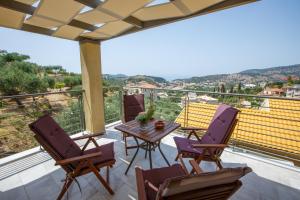 a patio with a table and chairs on a balcony at Théa boutique villas sivota III in Sivota