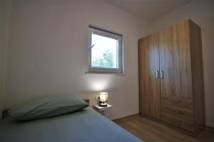 Schlafzimmer mit einem Bett, einem Fenster und einem Schrank in der Unterkunft Apartment RIO in Sečovlje