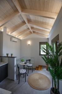 a living room with wooden ceilings and a table and chairs at Théa boutique villas sivota III in Sivota