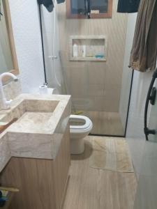 ein Badezimmer mit Waschbecken, Toilette und Dusche in der Unterkunft Casa de praia no Condomínio Guaratiba, Prado-BA in Prado
