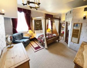 a bedroom with a canopy bed and a chair at Dukes Folly Hotel in Southport