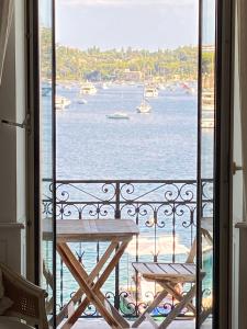 balcón con mesa y vistas al agua en Seagulls en Villefranche-sur-Mer
