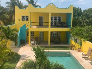 een geel huis met een zwembad ervoor bij Arenas Del Mar Condos in Chelem