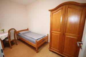 a small bedroom with a bed and a wooden cabinet at Ferienwohnungen Hof Heinzmann in Kohlstetten