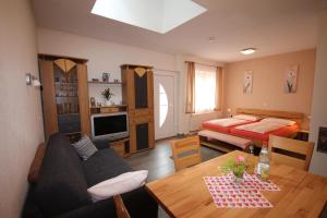 ein Wohnzimmer mit einem Sofa und einem Tisch in der Unterkunft Ferienwohnungen Hof Heinzmann in Kohlstetten