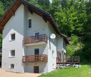 un gran edificio blanco con balcones de madera en Ferienwohnung Unsere Mühle, en Kirchbach