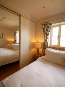 萊德伯里的住宿－Walwyn Court Barns，一间卧室配有两张床和镜子