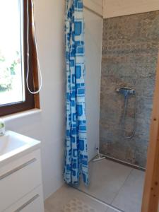 a bathroom with a shower with a blue and white shower curtain at Domek nad Szelągiem in Stare Jabłonki