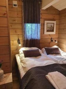 a bedroom with a large bed in a log cabin at Småstranda Fjord Lodge in Åheim