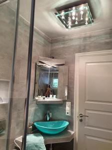 a bathroom with a blue sink and a mirror at Småstranda Fjord Lodge in Åheim +47 photos