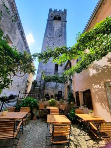 a patio with tables and chairs and a tower at Bed & Breakfast Antico in Motovun