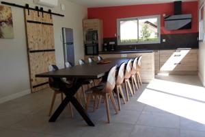 une cuisine avec une table et des chaises noires dans l'établissement La Cascatelle - Gîte entièrement climatisé, à Savigny-en-Revermont