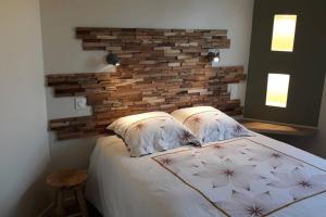 a bedroom with a bed with a brick wall at La Cascatelle - Gîte entièrement climatisé in Savigny-en-Revermont