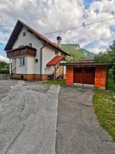 a house with a garage and mountains in the background at Apartmaji Tomšič in Mojstrana