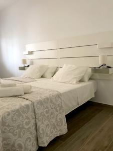 ein großes weißes Bett mit weißer Bettwäsche und Kissen in der Unterkunft La Pimentera Central Apartments - Marbella in Marbella