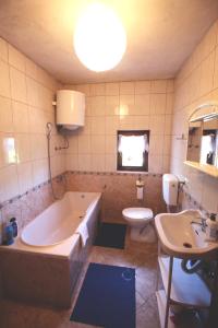 La salle de bains est pourvue d'une baignoire, de toilettes et d'un lavabo. dans l'établissement Apartman Komfor, à Banja Luka