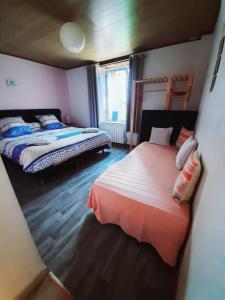 1 dormitorio con 2 camas y ventana en Le Logis des 3 Coeurs chambre Aeiou en Saint-Cernin-de-lʼHerm