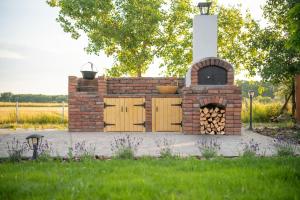 a brick fireplace with an oven in a yard at Natura Apartman Tiszafüred in Tiszafüred