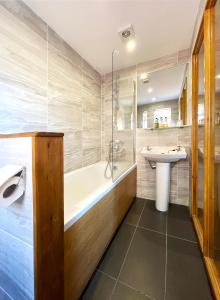 a bathroom with a tub and a sink and a bath tub at Dukes Folly Hotel in Southport