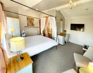 a bedroom with a large bed and a couch at Dukes Folly Hotel in Southport