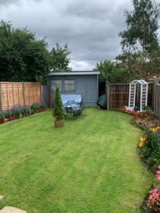 a backyard with a picnic table and some flowers at Single Unique Room For Professionals in Ealing