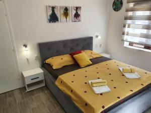 a bedroom with a large bed with yellow sheets at Studio Milenic in Trebinje