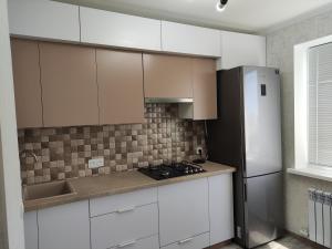 a kitchen with white cabinets and a refrigerator at Victoria in Tiraspol