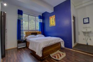 a bedroom with a bed with a blue wall at Aura Homes in Gangtok