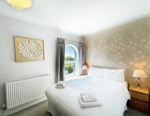 a bedroom with a white bed and a window at Dukes Folly Hotel in Southport