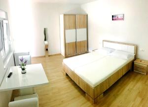 a bedroom with a bed and a table and a desk at Apartmani Maki in Omiš