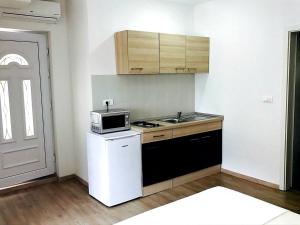 una piccola cucina con lavandino e forno a microonde di Apartmani Maki a Omiš (Almissa)