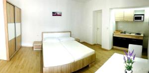 a bedroom with a large bed and a kitchen at Apartmani Maki in Omiš