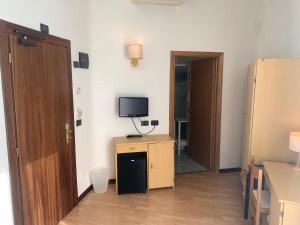 a small room with a television and a room with a door at Hotel Angiolino in Chianciano Terme