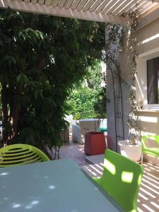 a table and two green chairs on a patio at Helene Villa in Protaras