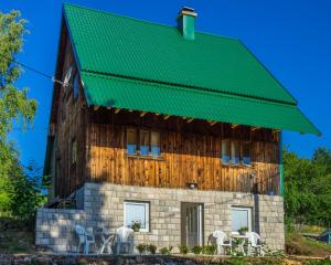 une grande maison en bois avec un toit vert dans l'établissement Apartments Stevovic, à Žabljak