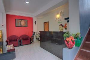 a waiting room with two red chairs and a fireplace at Aura Homes in Gangtok