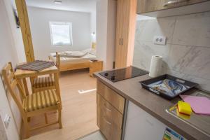 a kitchen with a counter and a table with a chair at Apartments Stevovic in Žabljak +48 photos